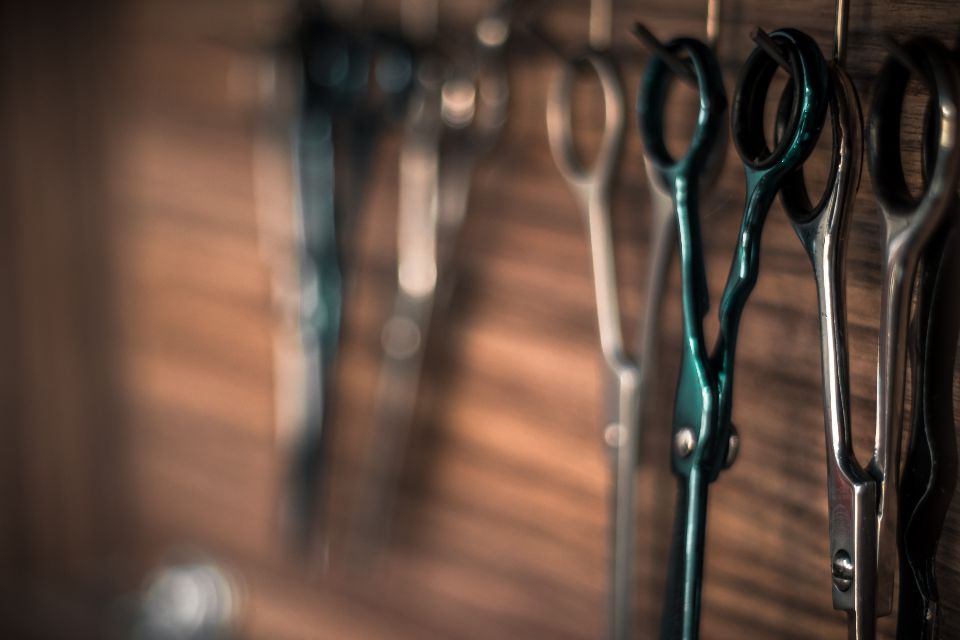 hairdressing scissors hanging on a wooden wall